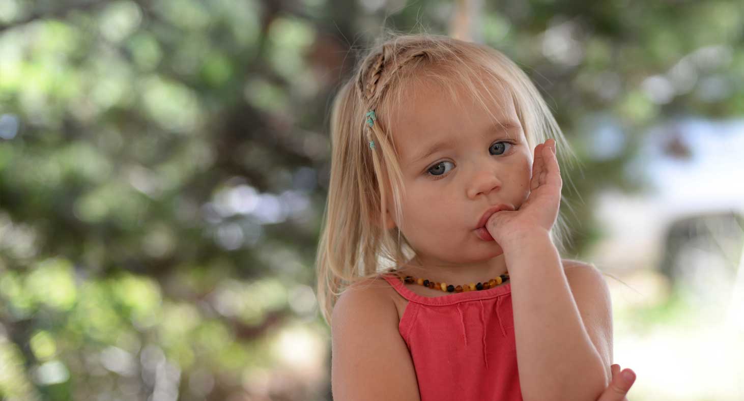 A little girl sucks her thumb, preparing herself to recieve dental care.
